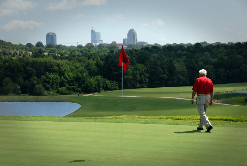 Arnold Palmer walks on a green at NC State's Lonnie Poole Golf Course.