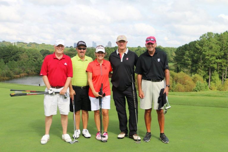 Participants in a golf outing pose for a photo.