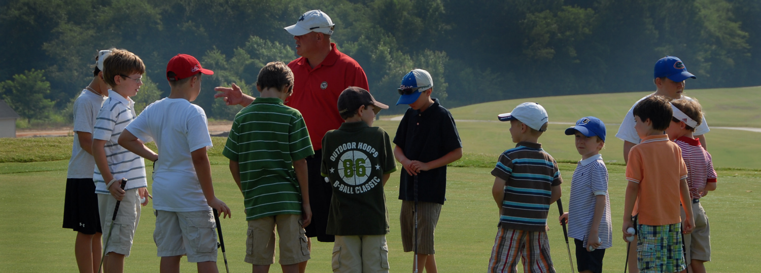 Young golf students listen to their instructor.